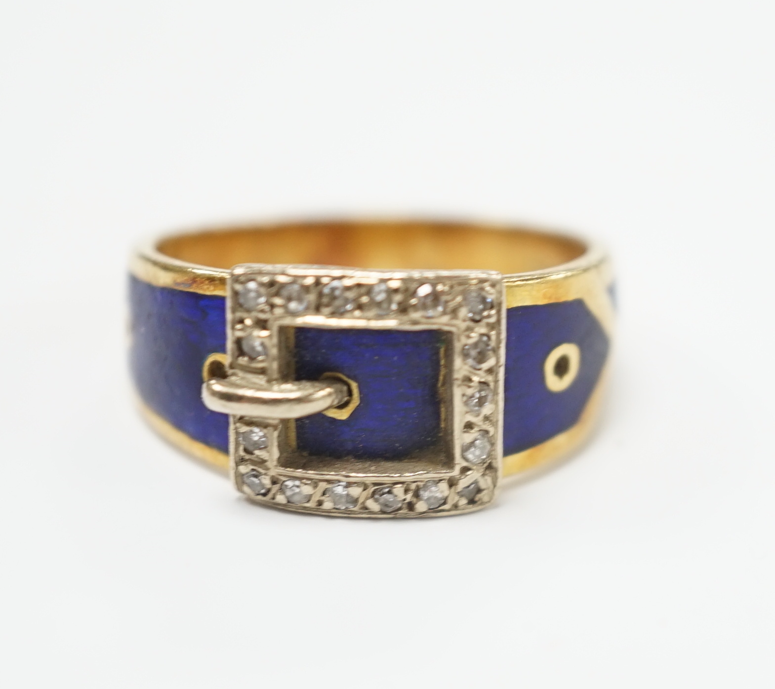 An early 20th century 18ct, diamond chip and blue enamel set buckle ring, size Q, gross weight 8.9 grams.